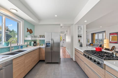 Modern kitchen pops with vibrant seaside-inspired colors & sleek finishes.