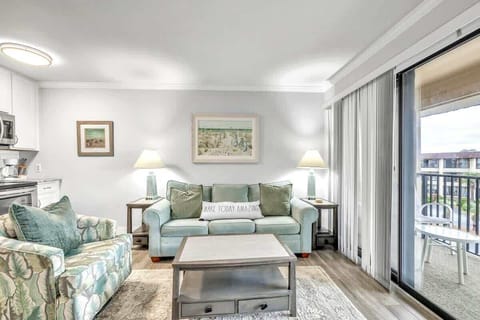 Bright living room with coastal-inspired seating and balcony access