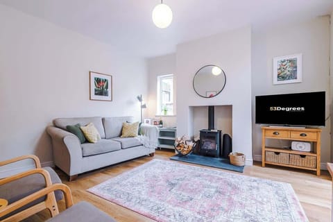 This home offers two stylish living rooms: a bright, modern lounge with a wood burner, Smart TV, and cosy seating, plus a warm, inviting snug with a red sofa, reading nook, and soft lighting. Perfect for relaxing, whether with a book or a film.