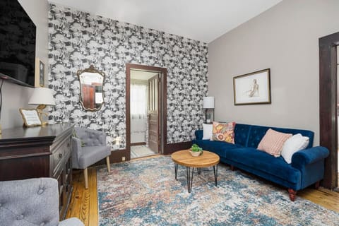 The living room's vibrant wallpaper adds a pop of charm, complemented by thoughtfully curated decor.