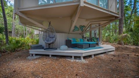 Tucked beneath the tree canopy, this inviting lower-level deck creates a relaxed outdoor living retreat.