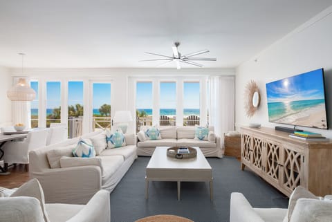 Unwind in this bright living space where ocean breezes flow through floor-to-ceiling windows, creating your perfect coastal retreat.