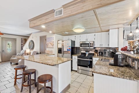 Fully stocked kitchen with 4 stools at the counter.