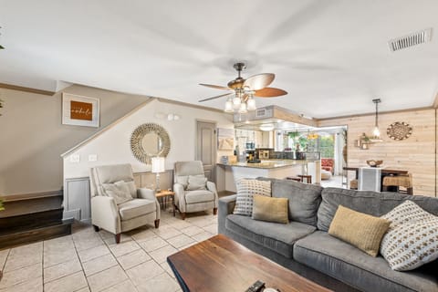 Living room with smart TV, sleeper sofa, half bathroom, and 2 accent chairs