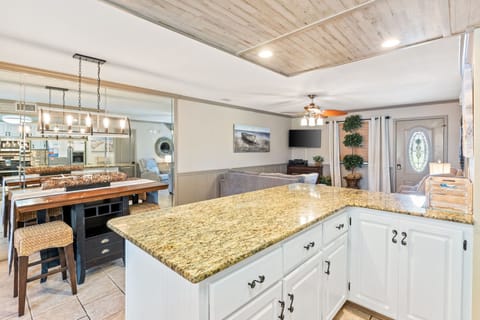 Fully stocked kitchen with 4 stools at the counter.