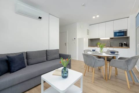 Living room, showing the round dining table and a bright, airy space. The living room is connected to the kitchenette. 