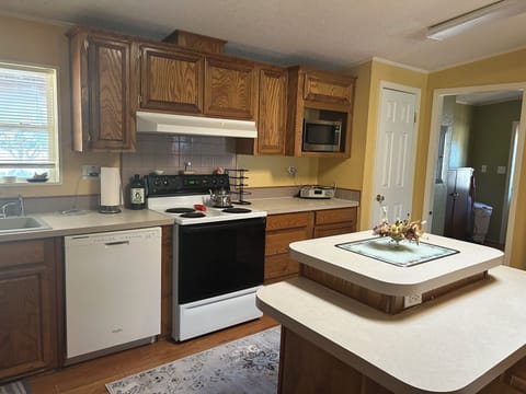 Large family style kitchen with dishes, cooking utensils provided