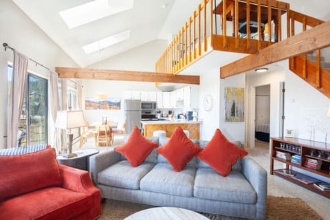 Open floor plan living room has a wood burning fireplace with majestic mountain views