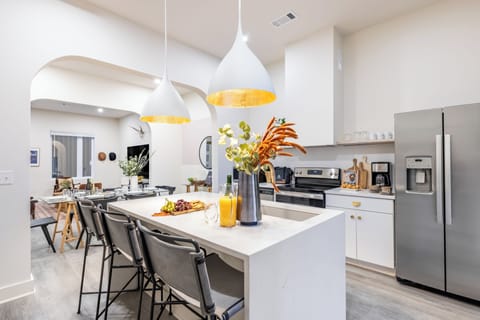 Sleek kitchen features an island with barstool seating.