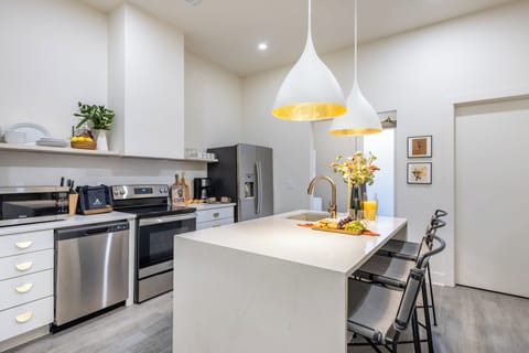 Kitchen features modern stainless-steel appliances.