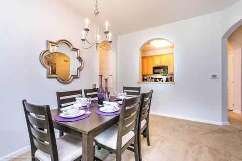 Chic dining area of the condo in Orlando Florida - Sophisticated design with a blend of modern and classic elements - Beautiful chandelier - Dining for 6 persons - Artfully arranged table settings for a touch of elegance