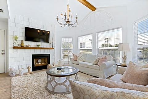 Exquisite and comfortable living room with elegant decor, a smart TV, and a decorative fireplace.