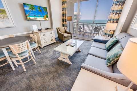 - Bright living room with ocean view balcony seating for relaxing mornings   - Comfortable sofa and flat screen TV create the perfect beach stay retreat   - Dining area and natural light enhance the coastal vacation vibe