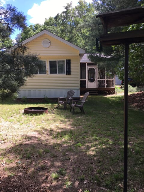 Front of cottage. Fire pit now with swing away grill. Firewood in screen porch. 