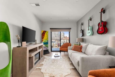 Living room with  full sleeper sofa, TV, games, and access to a private balcony