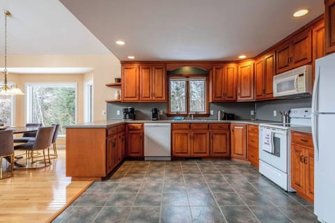 Bright, open-concept kitchen and dining area perfect for family meals and gatherings, featuring modern appliances and stunning mountain views.