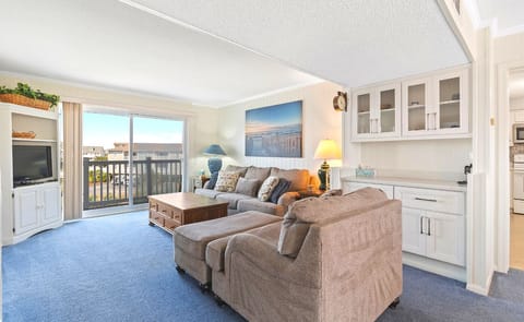 Bright and open living area with bar and sliding glass doors leading to the back porch
