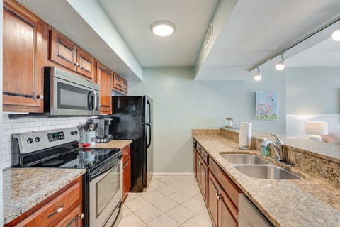 Cook up coastal meals with ease in the fully equipped kitchen featuring granite countertops, stainless steel appliances, and warm wood cabinetry. Whether you`re preparing a quick snack or a family dinner, this space has everything you need.