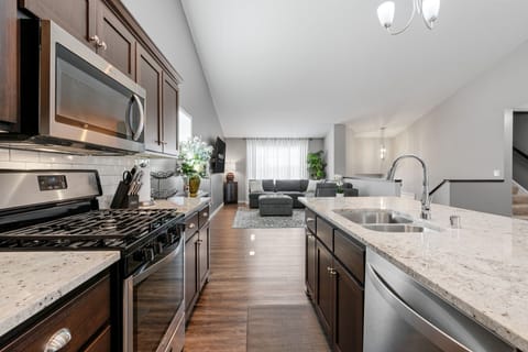 Step into your sleek kitchen where stainless steel appliances and granite counters await your culinary adventures.