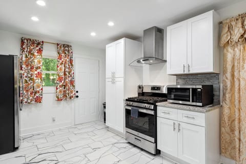 An airy, stylishly designed, fully equipped kitchen with a contemporary cooktop.