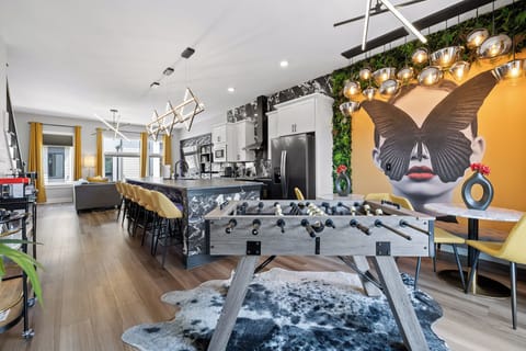 The Gathering Hub: Two dining tables and foosball open to the chef's kitchen