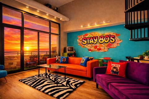 Experience vibrant retro energy inside and breathtaking waterfront sunsets outside. Relax on your private balcony, soak in golden-hour views, and enjoy a one-of-a-kind 80s-themed stay near top attractions.