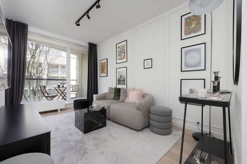 The living area features a sleek coffee table and a flat-screen television.