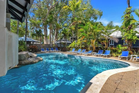 Take a dip in the building’s shared outdoor pool, surrounded by lush greenery and sun loungers for your relaxation.