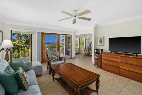Relax in your spacious living room where tropical breezes and stunning ocean views flow through open doors, creating the perfect island escape with all the comforts of home.