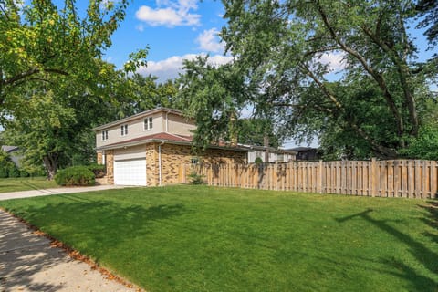 Brick-and-siding exterior with two-car garage and manicured lawn.