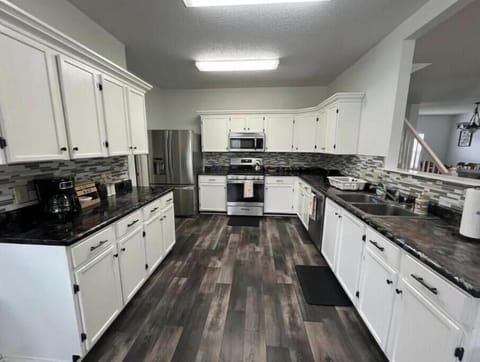 Fully stocked kitchen with appliances, cookware, and kids’ dinnerware.
