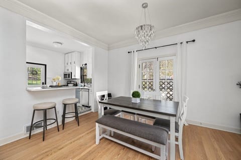 Bright kitchen with white cabinets, stainless steel appliances, and island seating.
