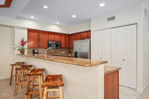 Full kitchen with breakfast bar, granite counters, and stainless steel appliances