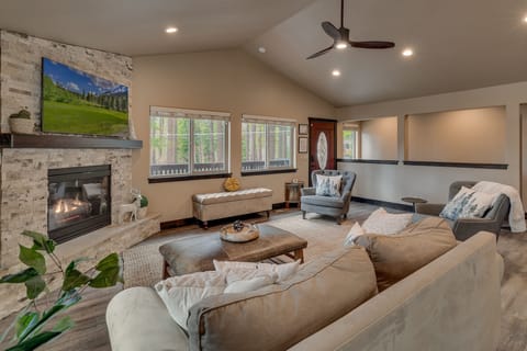 - Fireplace living room with rustic stone surround décor  
- Spacious seating area with mountain charm and natural light  
- Perfect cabin lounge for cozy evenings and family fun