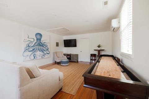 Game room, enjoy year‑round fun with shuffleboard, Smart TV, lounge seating, and dedicated climate control.
