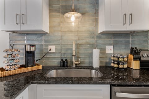 Stylish kitchen corner with an eye-catching turquoise tile backsplash, where functionality meets modern design aesthetics.