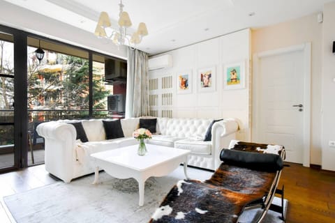 Unwind in elegance: Our spacious living room offers comfort and style with plush seating and panoramic views of lush gardens.