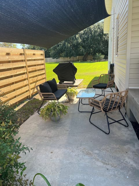 Exterior Front side patio w/ shade sail cover and charcoal barbecue grill