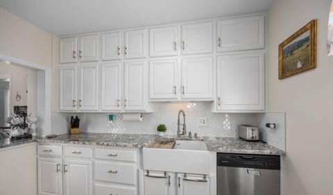 Efficient Galley kitchen with Large farmhouse sink and dishwasher.