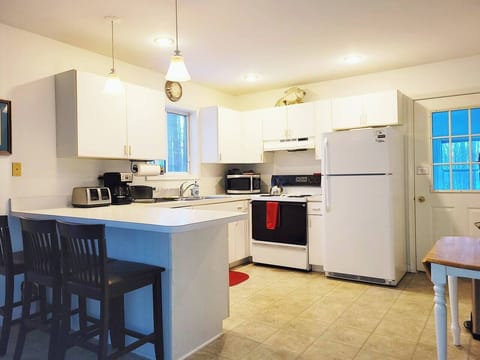 Fully stocked kitchen has refrigerator, electric stove, microwave, dishwasher, toaster, drip coffee maker, blender and more