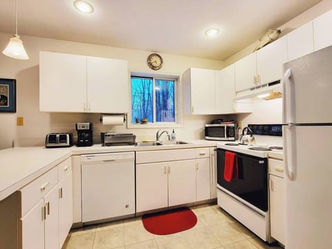 Fully stocked kitchen has refrigerator, electric stove, microwave, dishwasher, toaster, drip coffee maker, blender and more