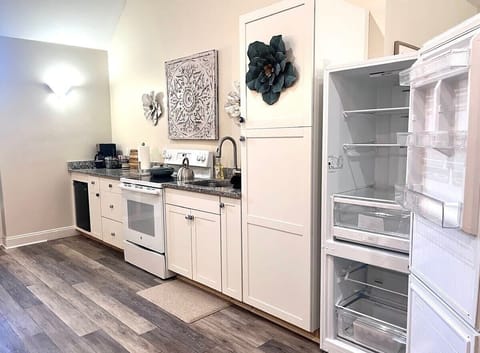 Kitchen with full size fridge, mini-fridge, oven,  four-burner range.