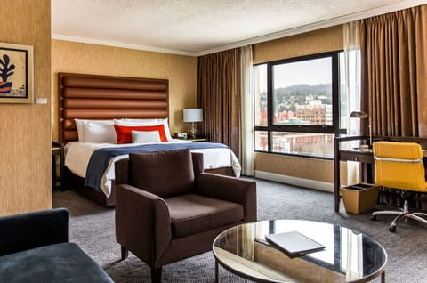 A spacious retreat with a comfortable king-sized bed and a separate living area, adorned with plush seating and ample natural light.