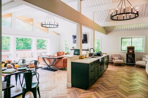 The open Great Room has a beautiful wall of windows looking out into the Vermont wilderness. Chevron flooring makes the space look and feel unique.