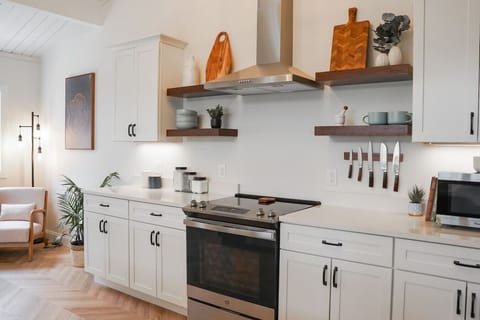 At the center of the kitchen are 4 beautifully decorated floating shelves and a fully functional stainless-steel hood. You would be hard-pressed to find a short-term rental this accommodating for aspiring chefs.