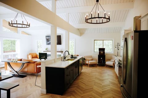 The kitchen and Great Room at Legacy Chalet. The chevron floor and open concept brings a certain uniqueness to the space. The kitchen is well-equipped with several appliances and features.