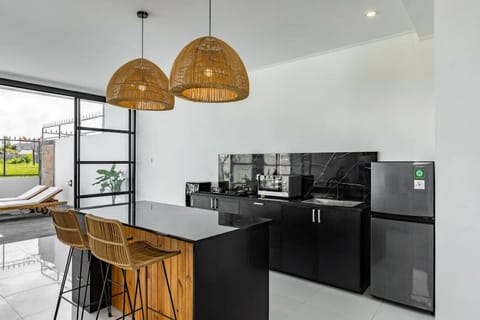 Minimalist kitchen with bamboo pendant lights and a breakfast bar.
