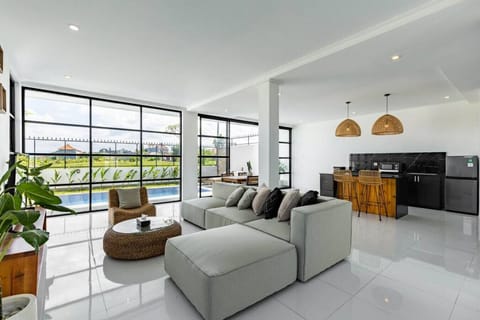 Bright and airy open-plan living space with pool view, modern kitchen, and comfy lounge area.