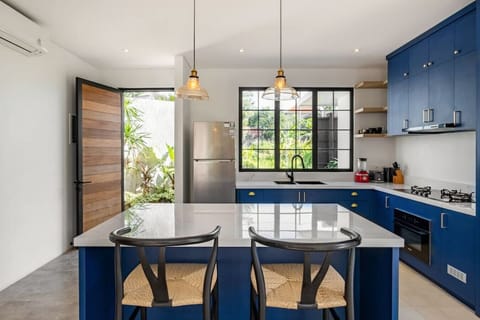 Spacious dining and kitchen area with a pop of blue and ample natural light.