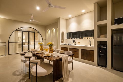 A beautifully designed kitchen-dining space, accented with natural wood and fresh flowers, offers a perfect blend of style and serenity.